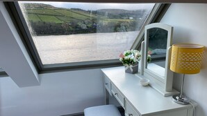 A room with a white vanity, a bench, a window with a view of a river and hills, and a lamp. - Traditional cottage with stunning views and walks on the doorstep. (Holmbridge)
