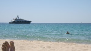 A beach with a yacht in the water and a person swimming. - Three-flag house with a view of the Gulf of Porto-Vecchio / quiet location (Porto-Vecchio)