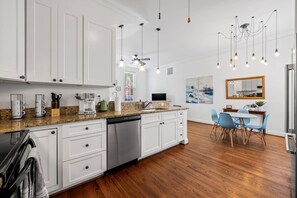 A modern kitchen with white cabinets, a dishwasher, and a granite countertop. - Fells Point - Close to Attractions (Baltimore)