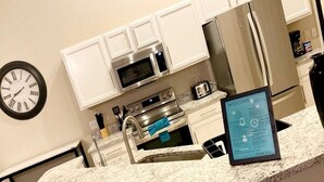 A modern kitchen with white cabinets, stainless steel appliances, a granite countertop, and a welcome sign. - Peaceful home with Pool Dog friendly 4 Bedrooms 3 Bathrooms backyard view water. (Davenport)