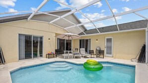 An indoor swimming pool with a glass ceiling, surrounded by lounge chairs and a table. - Peaceful home with Pool Dog friendly 4 Bedrooms 3 Bathrooms backyard view water. (Davenport)