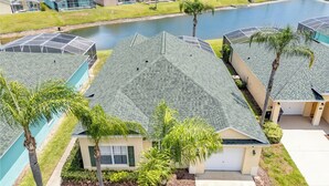 A residential area with houses featuring sloped roofs and a small body of water in the background. - Peaceful home with Pool Dog friendly 4 Bedrooms 3 Bathrooms backyard view water. (Davenport)
