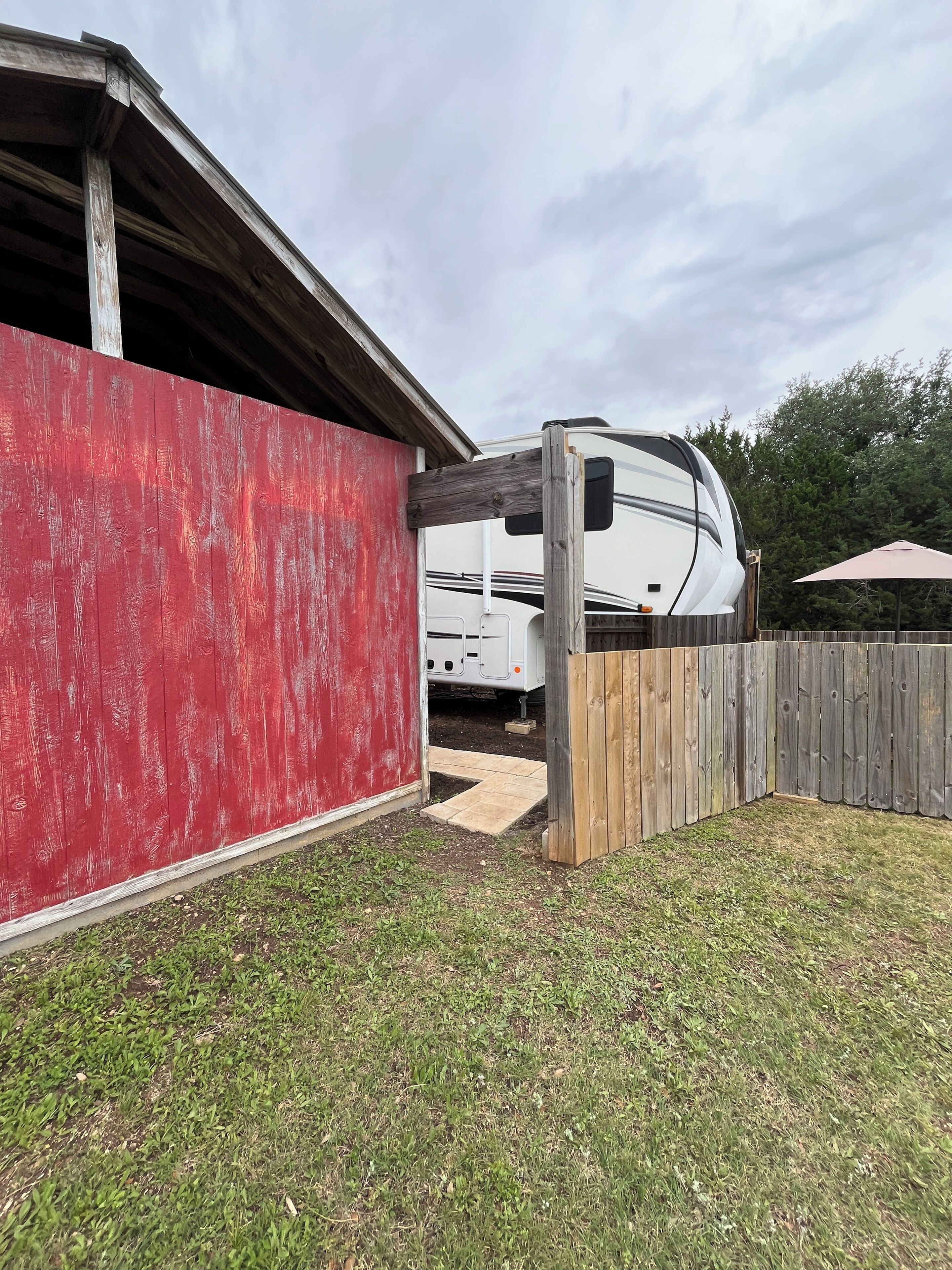 A red building with a white RV parked in front.
