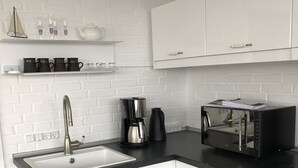 A modern kitchen with white cabinets, a black countertop, a sink, a coffee maker, and a toaster. - Fully rented accommodation with Christina as host (Gråsten)