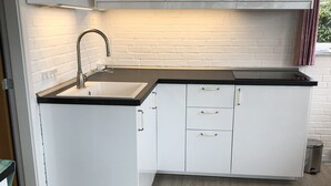 A kitchen with white cabinets, a black countertop, and a stainless steel sink. - Fully rented accommodation with Christina as host (Gråsten)
