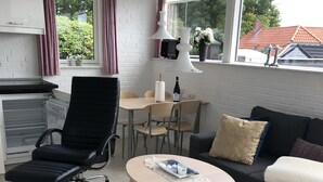 A modern living room with a black office chair, a round coffee table, a sofa, and a dining table with chairs. - Fully rented accommodation with Christina as host (Gråsten)