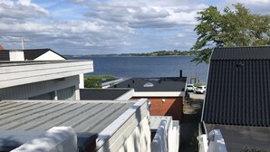 A narrow pathway leading to a waterfront view, flanked by white walls and a brick building. - Fully rented accommodation with Christina as host (Gråsten)