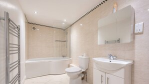 Ein modernes Badezimmer mit Badewanne, Toilette und Waschbecken.
