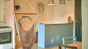 A kitchen with a blue countertop, a hanging hammock, and a stove.