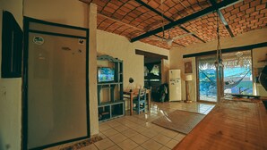 A spacious kitchen with a tiled floor, a wooden dining table, and a refrigerator.