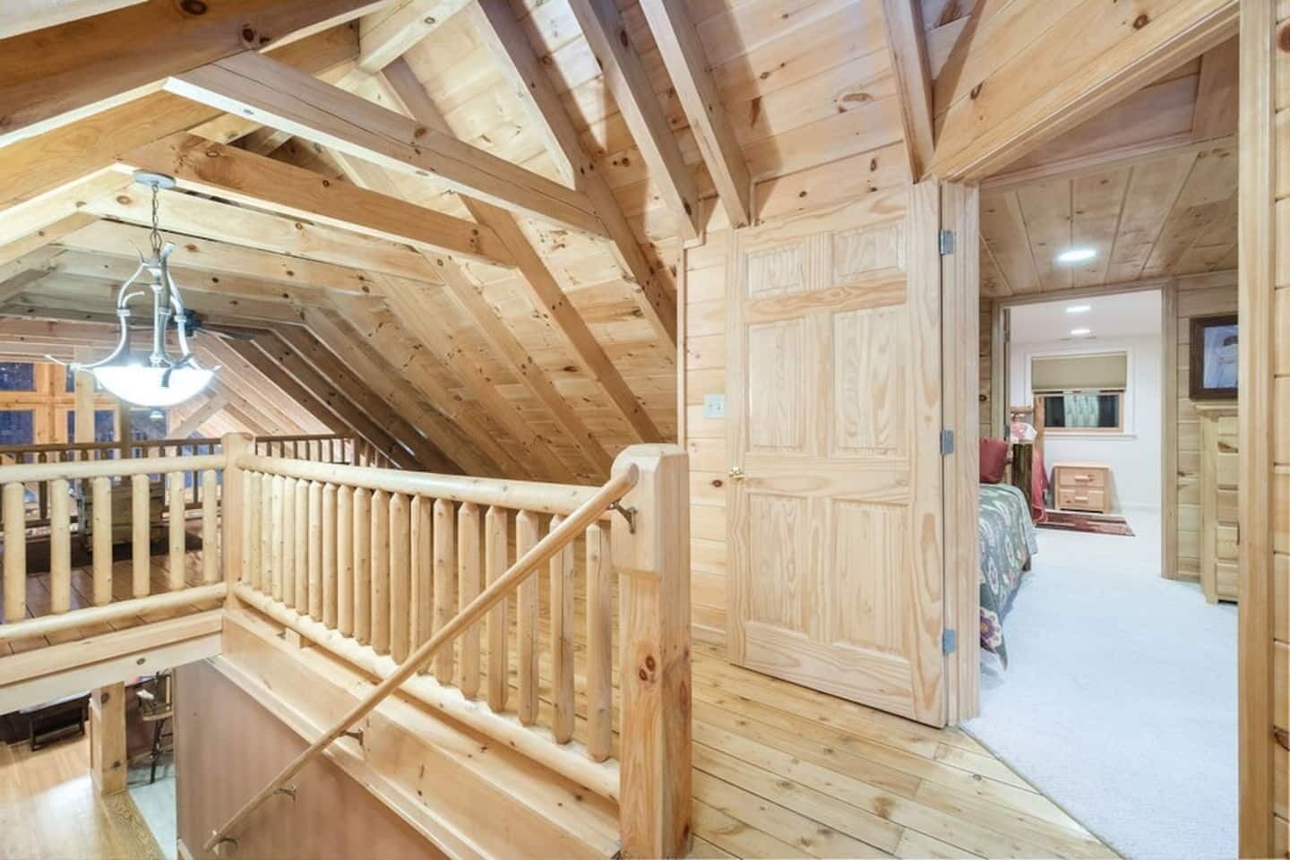 A wooden interior with a staircase leading to a bedroom.