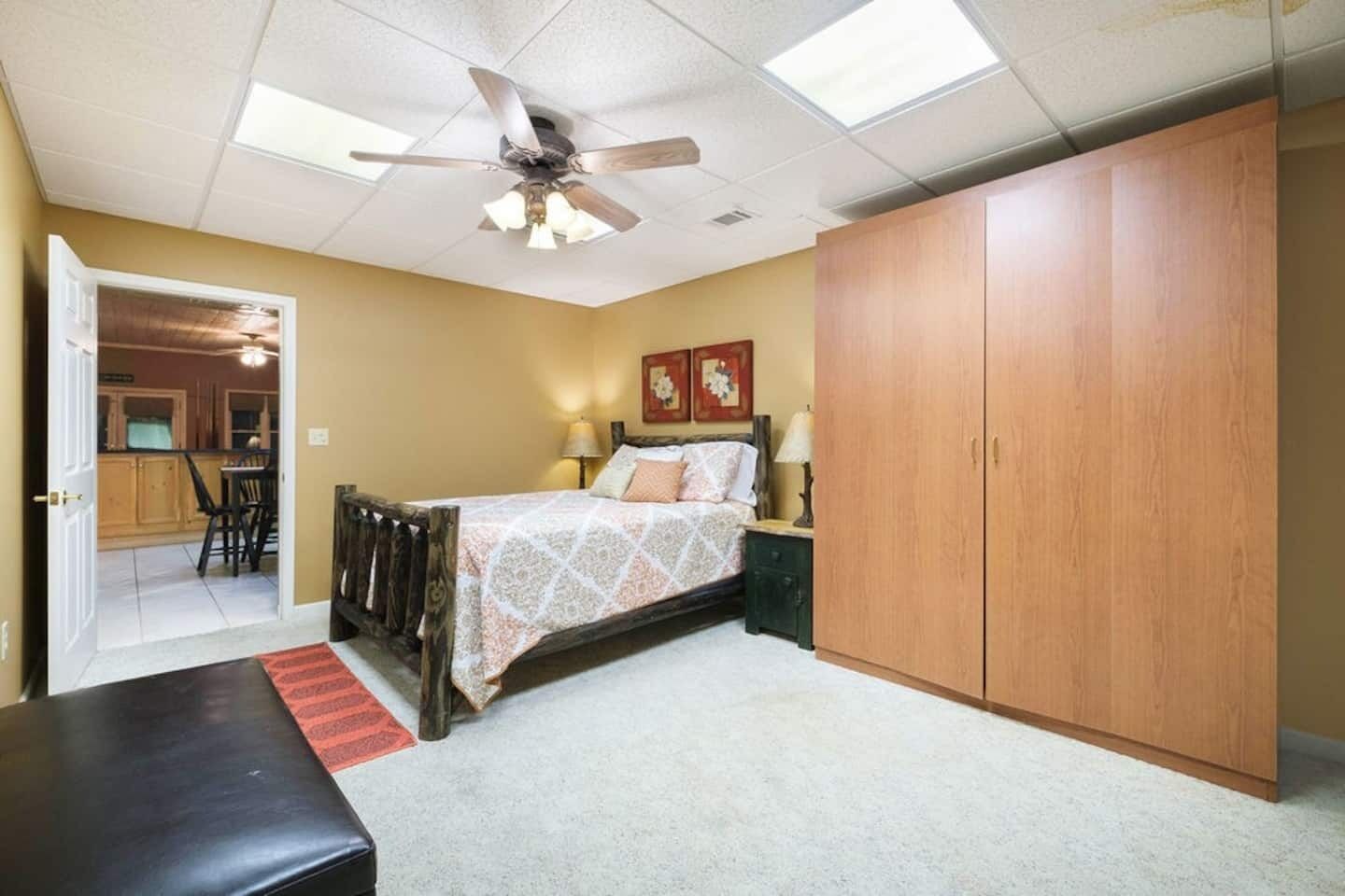 A bedroom with a bed, a wardrobe, a desk, and a chair.