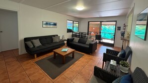 A living room with two sofas, a coffee table, and a dining area with chairs and a table. - Fantastic enclosed outdoor area, fully fenced, close to shops, Eurong Beach (Eurong)