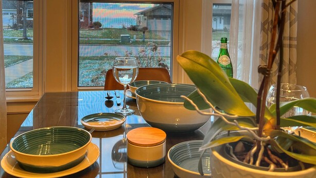 Une table à manger avec différents plats et une plante en pot.