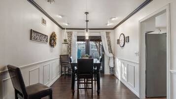 A dining area with a wooden table, chairs, and a chandelier.