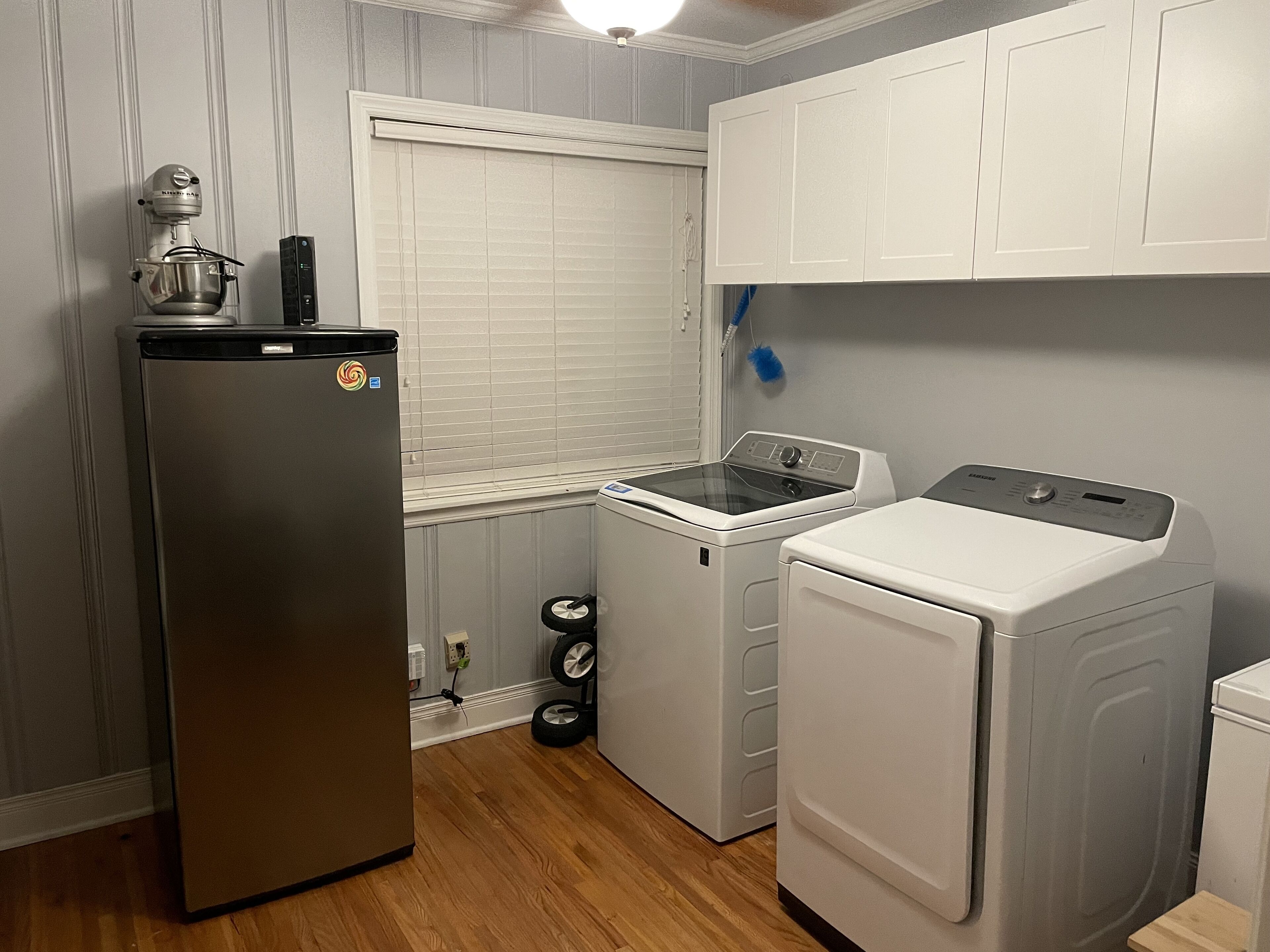 A compact kitchen with a refrigerator, washing machine, and dryer.