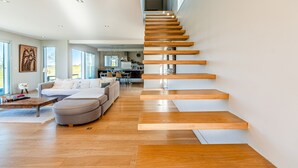 Un salon moderne avec un escalier en bois, un canapé et une table basse.