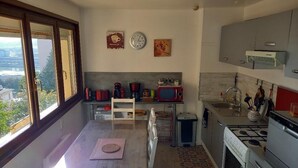 A modern kitchen with a large window, a microwave, a stove, and a sink.
