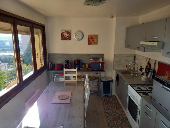 Una cucina moderna con un'ampia finestra, un forno a microonde, un piano cottura e un lavello.