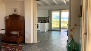A spacious room with a wooden chair, a patterned rug, and a green vase with dried flowers. - Luxury villa, swimming pool, shaded terraces, panoramic view, sauna fitness room (CAMPAGNATICO (GR))