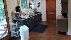 A compact kitchen with a sink, stove, and a small refrigerator. - Remodeled house in Gamboa. Next to the Panama Canal, nature and tranquility. (Gamboa)
