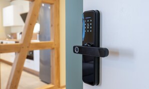 Ein modernes, an der Wand montiertes elektronisches Türschloss mit Tastatur.