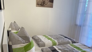 Ein Einzelbett mit gesteppter Bettdecke und gestreiften Kissen.