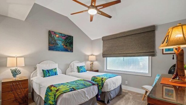 A bedroom with two beds, a ceiling fan, a window with a view, and a desk with a lamp. - Ma'alaea Surf #C-7 – Oceanfront Getaway with Spectacular Views & Pool (Kihei, Maui)