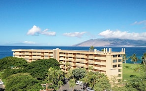 Un hotel de varios pisos con balcones que dan a la costa.
