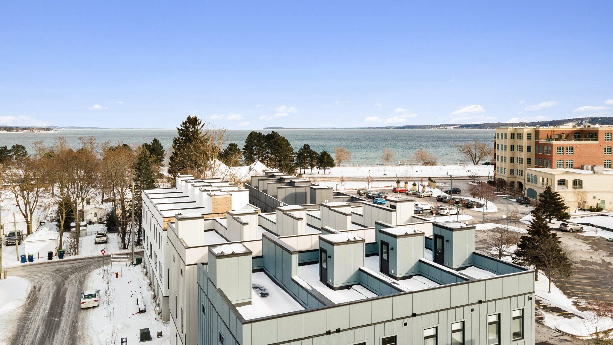 Un bâtiment moderne doté d’un toit plat, entouré d’un paysage enneigé et d’arbres.