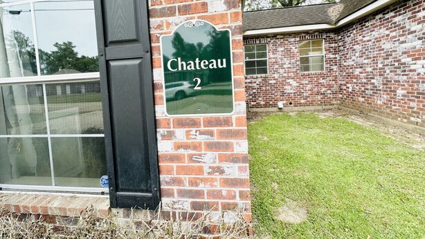 Un edificio in mattoni con un cartello che riporta la scritta "Chateau 2" e una finestra.