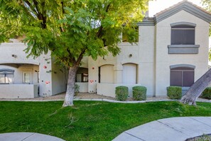 A two-story building with a stucco exterior, a large tree in front, and a well-maintained lawn. - 2 King Suites with Heated Pools/Spas/Gym in great North Scottsdale Location! (Scottsdale)