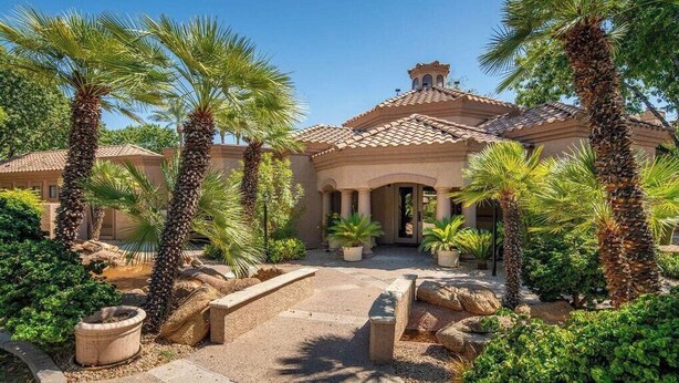 A Mediterranean-style building with a tiled roof, surrounded by palm trees and potted plants. - 2 King Suites with Heated Pools/Spas/Gym in great North Scottsdale Location! (Scottsdale)