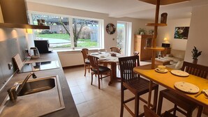 A modern kitchen with a dining area, large windows, and a view of the backyard. - 5-star vacation apartment "Hedfan" in Cnauceltaidd (Halle)