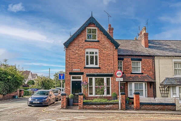 A red brick building with a gabled roof, a 'Café' sign, and a 'No Parking' sign.