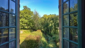 Vista a través de una ventana con cielo despejado y vegetación al exterior.