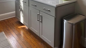 A kitchen with grey cabinets, a coffee machine, and green mugs on the counter. - Spectacular Location: State Circle Apartment (Annapolis)