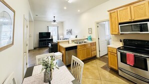 A compact kitchen with wooden cabinets, a microwave, and an oven. - Chateau 7, spacious townhouse in Tickfaw, LA (Tickfaw)