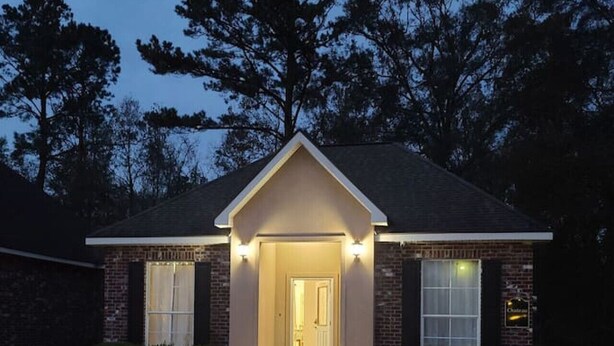 A two-story house with a front entrance, a brick facade, and a small porch area. - Chateau 7, spacious townhouse in Tickfaw, LA (Tickfaw)
