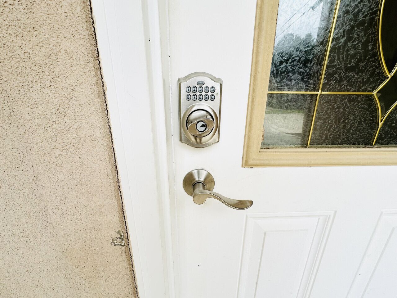 A white door with a keypad lock and a lever handle.