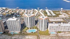 Un quartier résidentiel composé d’immeubles à étages, doté de plusieurs piscines et d’un port de plaisance avec des bateaux.