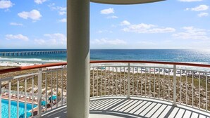 Un balcon avec vue sur la plage, l’océan et une jetée.