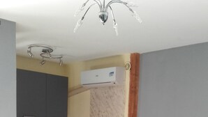 Een knus woongedeelte met een kitchenette, een bank en een kleine tafel.