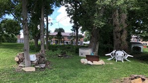 A grassy yard with trees, a shed, and scattered objects.