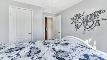 Een slaapkamer met een bed, twee witte deuren, een plafondventilator en een kaartdecoratie aan de muur.