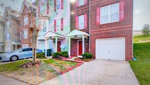 A row of townhouses with a garage, a driveway, and a small tree in the front yard. - DC  Townhouse  close to Capitol (Washington)