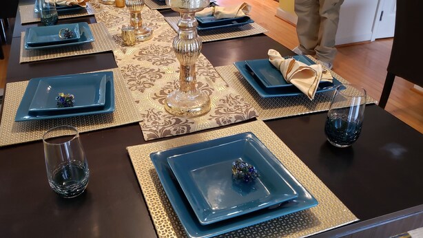 A dining table set with blue square plates, gold placemats, and clear glassware. - DC  Townhouse  close to Capitol (Washington)