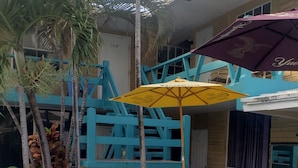 Una zona de pati amb una barbacoa, seients exteriors i una piscina.