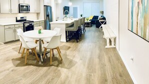 A modern kitchen with white cabinets, a built-in microwave, and a stainless steel refrigerator. - Coastal Charm- 4BR  Spacious, with Resort Pool- Bright and Inviting (Ocean View)