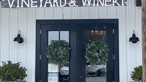 A building entrance with a sign reading "Salted Vines Vineyard & Winery". - Coastal Charm- 4BR  Spacious, with Resort Pool- Bright and Inviting (Ocean View)